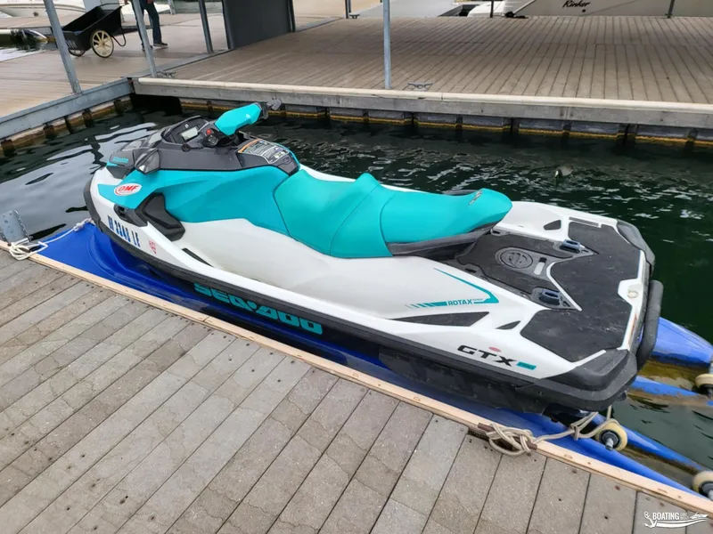 Slide: The Image of 2022 Sea-Doo GTX PRO 130 jet ski docked on a wooden pier. - 2