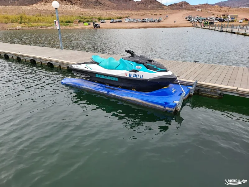Slide: The Image of 2022 Sea-Doo GTX PRO 130 jet ski docked on a calm lake. - 3