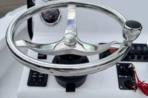 Slide: The Image of 2025 Action Craft 17 Flats boat steering wheel and dashboard controls. - 15