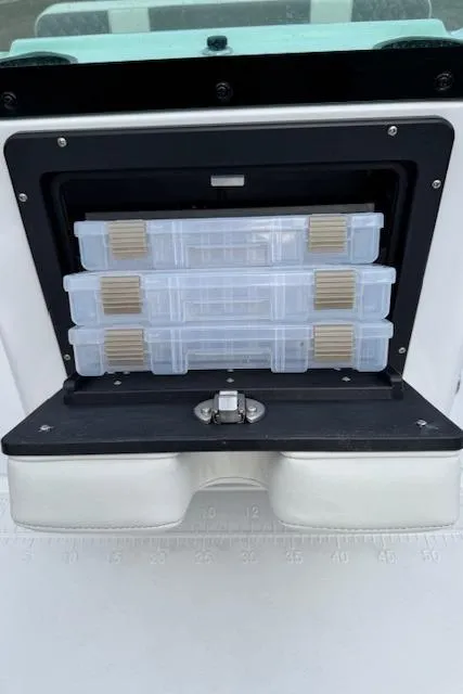 Slide: The Image of 2025 Action Craft 17 Flats boat storage compartment with organized tackle boxes. - 16