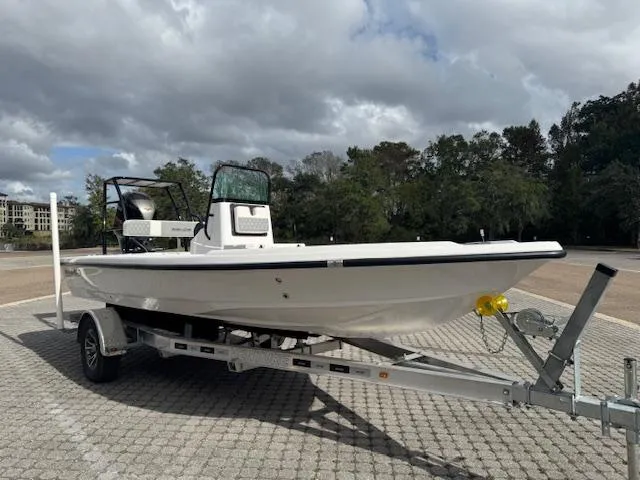 Slide: The Image of 2025 Action Craft 17 Flats boat on trailer, parked outdoors under cloudy sky. - 2