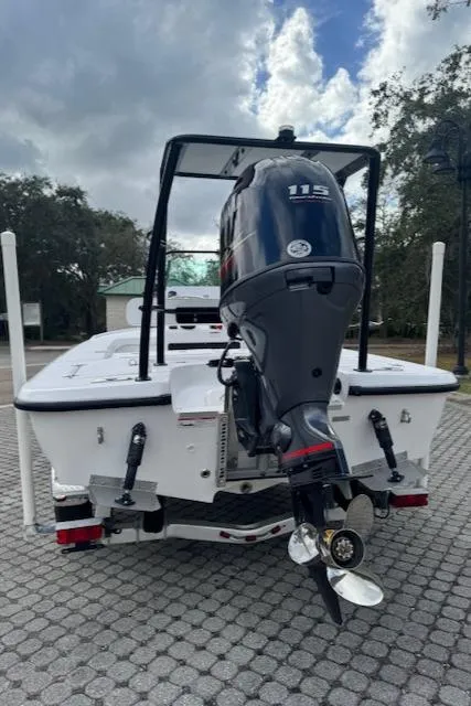 Slide: The Image of 2025 Action Craft 17 Flats boat with powerful outboard motor, parked on paved surface. - 26