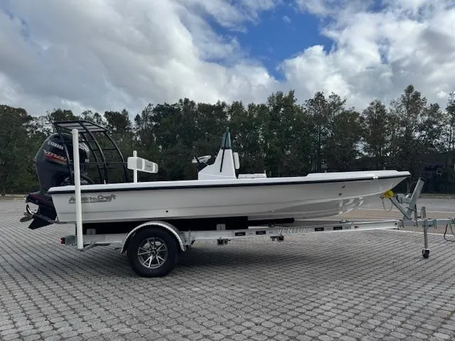 Slide: The Image of 2025 Action Craft 17 Flats boat on trailer, parked outdoors under cloudy sky. - 3