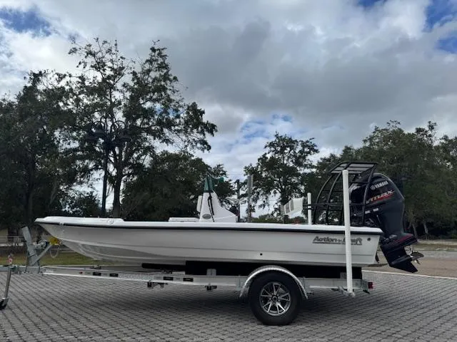 Slide: The Image of 2025 Action Craft 17 Flats boat on trailer, parked outdoors under cloudy sky. - 4