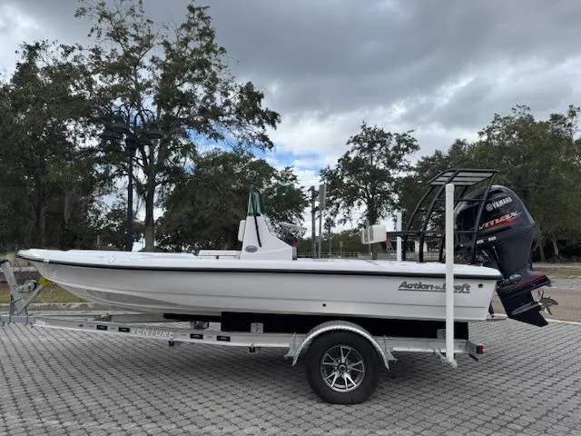 Slide: The Image of 2025 Action Craft 17 Flats boat on trailer, parked outdoors under cloudy sky. - 7