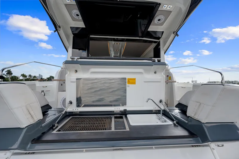 Slide: The Image of 2018 Jeanneau Leader 46 yacht with outdoor kitchen and seating, under a clear blue sky. - 26