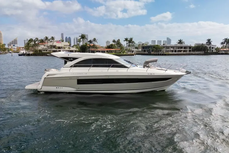 Slide: The Image of 2018 Jeanneau Leader 46 yacht cruising on a sunny day near a coastal city. - 3