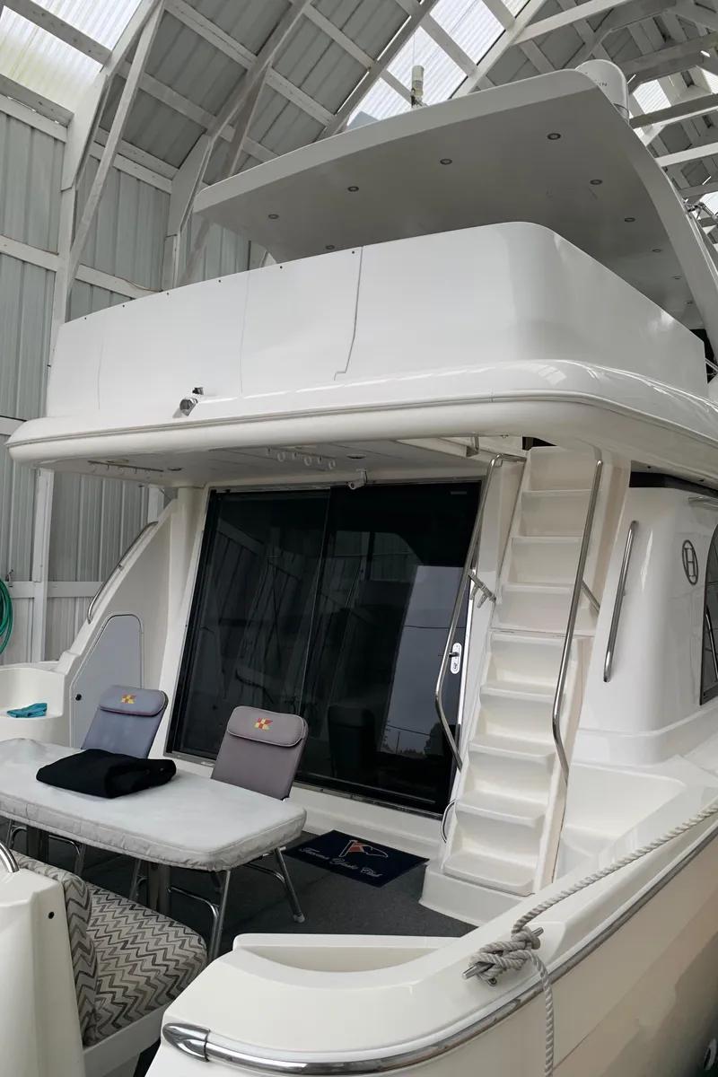 Slide: The Image of 1997 Bayliner Pilothouse interior with seating and table, docked near other boats. - 18