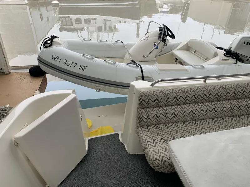 Slide: The Image of 1997 Bayliner Pilothouse boat in covered storage, showcasing sleek design and white exterior. - 8