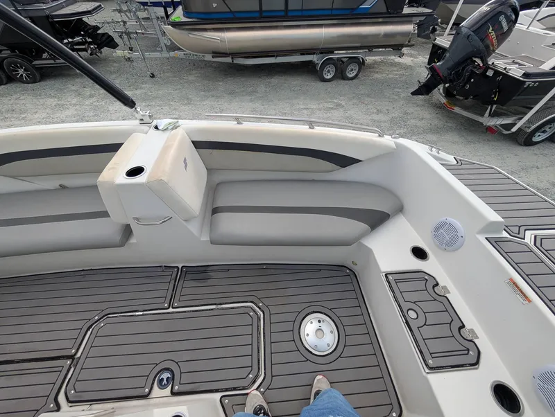 Slide: The Image of 2020 Starcraft SVX 171 boat interior with gray seating and deck, docked near other boats. - 7