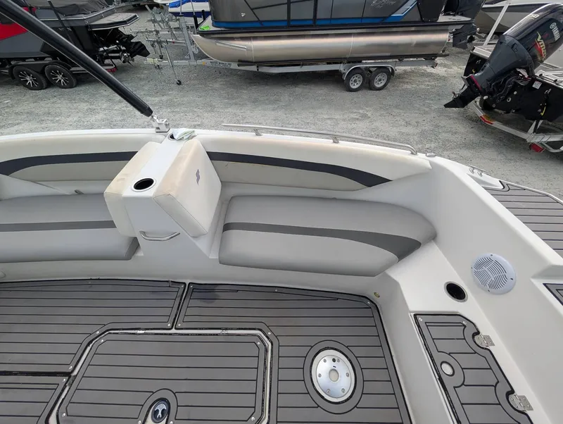 Slide: The Image of 2020 Starcraft SVX 171 boat interior with gray seating and deck, parked on gravel. - 8