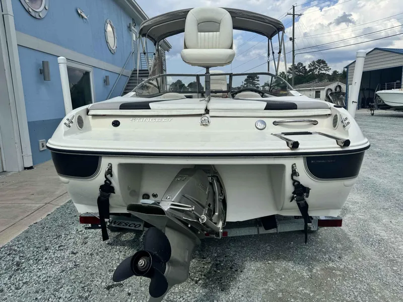 Slide: The Image of 2009 Stingray 195 FX Fish & Ski boat, rear view with outboard motor, parked outdoors. - 11