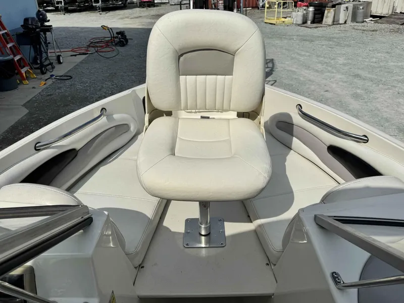 Slide: The Image of 2009 Stingray 195 FX Fish & Ski boat with white seating in a marina setting. - 7