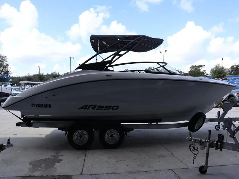 Slide: The Image of 2025 Yamaha Boats AR250 on trailer under blue sky. - 3