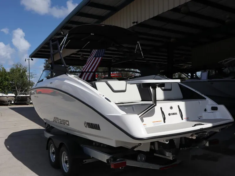 Slide: The Image of 2025 Yamaha AR250 boat on trailer, parked outdoors under a canopy. - 5