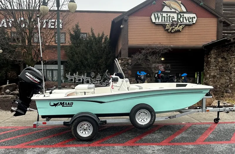 Slide: The Image of 2025 Mako Pro Skiff 15 CC boat on trailer outside White River Fly Shop. - 0