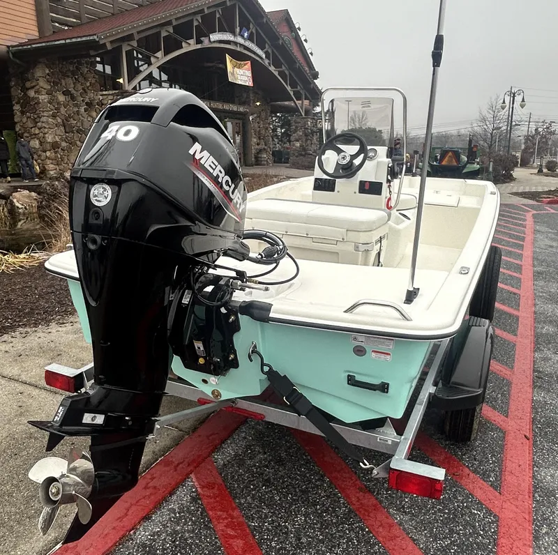 Slide: The Image of 2025 Mako Pro Skiff 15 CC with Mercury outboard motor on trailer. - 2