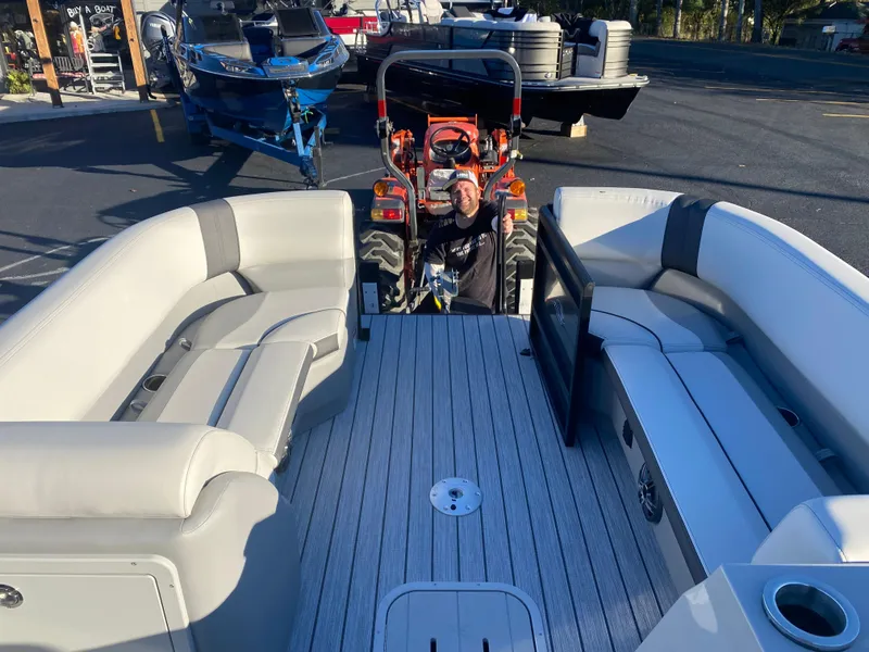 Slide: The Image of 2025 SunCatcher Select 322RC pontoon boat interior with tractor in background. - 16