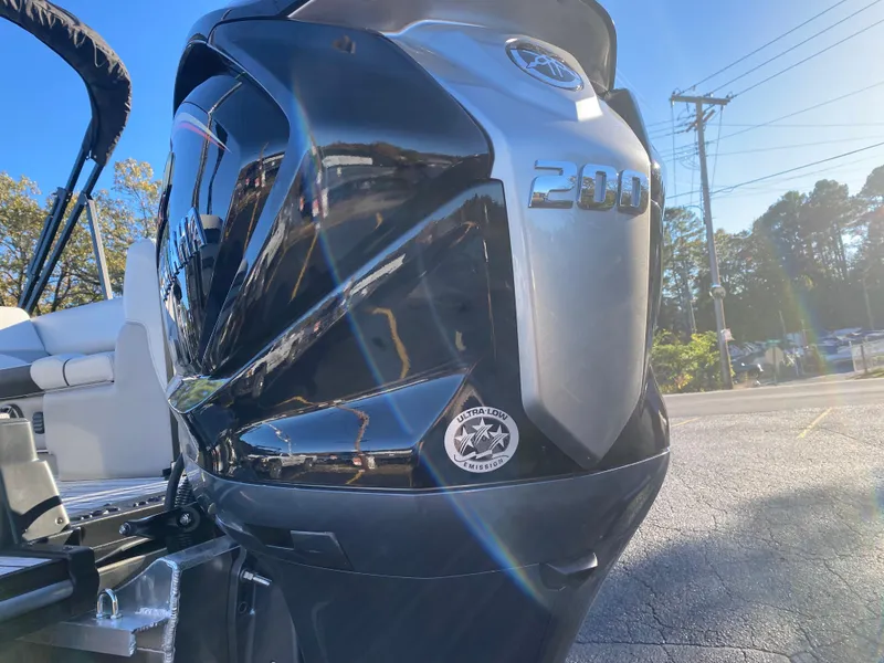 Slide: The Image of 2025 SunCatcher Select 322RC boat engine, shiny black and silver, outdoors in sunlight. - 2