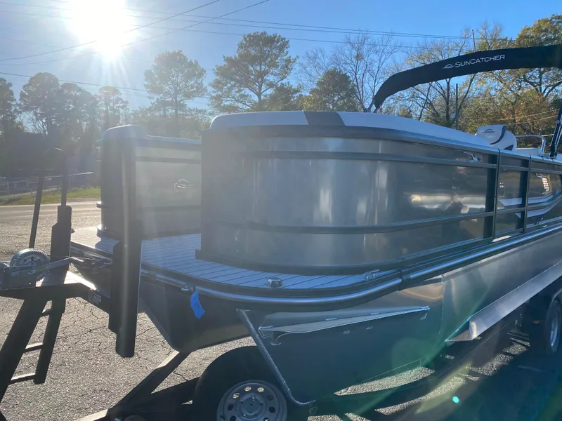 Slide: The Image of 2025 SunCatcher Select 322RC pontoon boat in sunlight, parked on a trailer. - 4