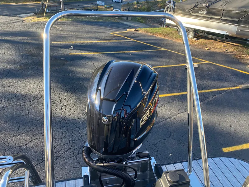 Slide: The Image of Outboard motor on 2025 SunCatcher Select 322RC boat in parking lot. - 7