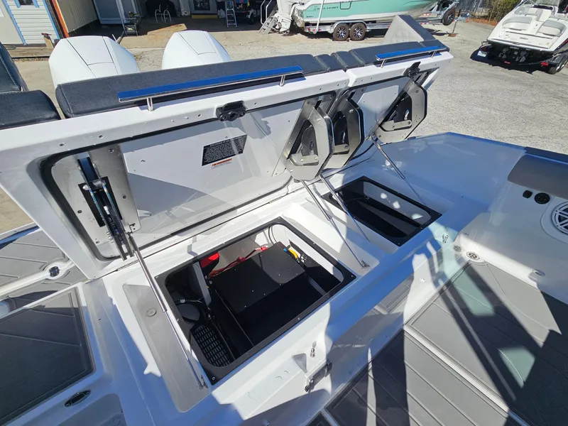 Slide: The Image of 2025 Monterey Elite 30 OB boat with open storage compartments and dual outboard engines. - 19