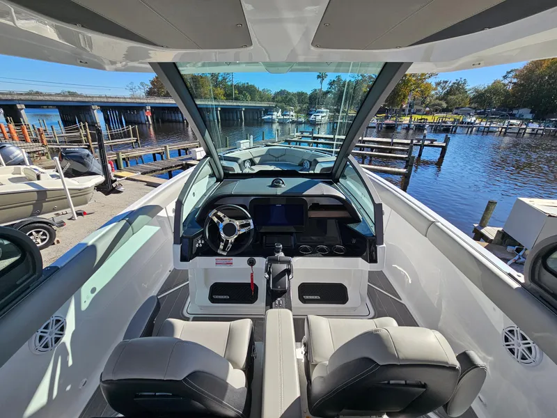 Slide: The Image of 2025 Monterey Elite 30 OB boat interior with modern dashboard and waterfront view. - 26