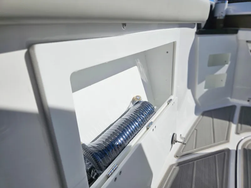 Slide: The Image of 2025 Monterey Elite 30 OB boat storage compartment with coiled hose. - 37