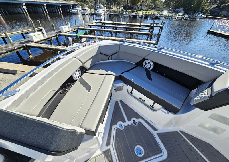 Slide: The Image of 2025 Monterey Elite 30 OB boat interior with spacious seating at a marina. - 39