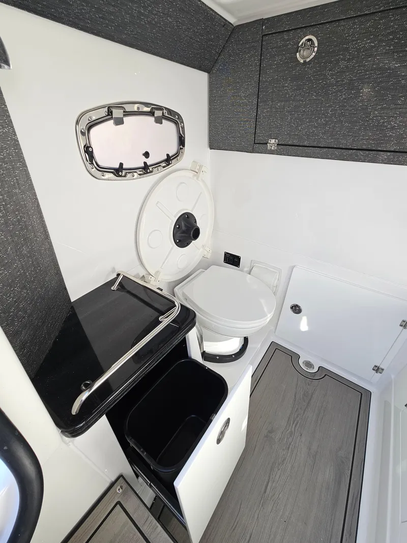 Slide: The Image of 2025 Monterey Elite 30 OB boat interior with compact bathroom and modern fixtures. - 44