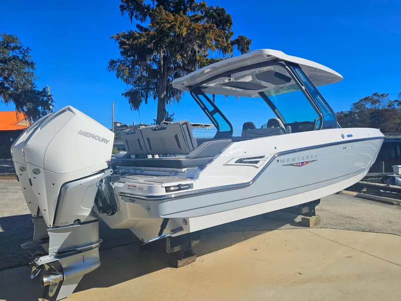 Slide: The Image of 2025 Monterey Elite 30 OB boat with Mercury outboard engine, docked outdoors. - 6