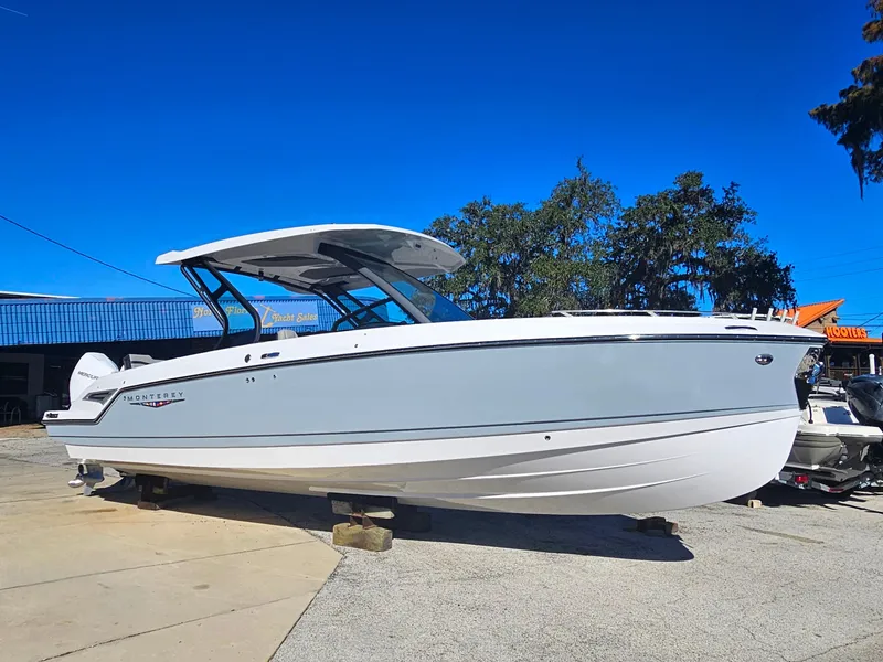 Slide: The Image of 2025 Monterey Elite 30 OB boat displayed outdoors on a sunny day. - 8
