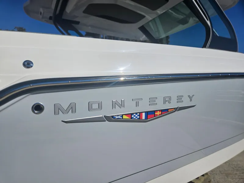 Slide: The Image of 2025 Monterey Elite 30 OB boat side view with logo and nautical flags. - 9