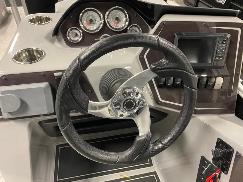 Slide: The Image of 2025 SunCatcher Fusion 324SS boat dashboard with steering wheel and gauges. - 12
