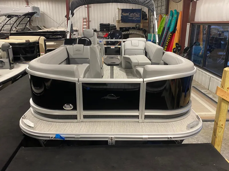 Slide: The Image of 2025 SunCatcher Fusion 324SS pontoon boat in showroom, featuring sleek black design and spacious seating. - 3