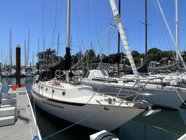 Slide: The Image of 1987 Pacific Seacraft PS37 sailboat docked in marina under clear blue sky. - 1