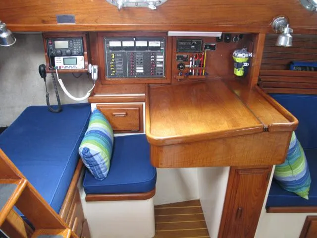 Slide: The Image of Interior of 1987 Pacific Seacraft PS37 sailboat with navigation station and blue cushions. - 10