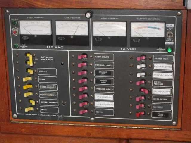 Slide: The Image of Electrical control panel of a 1987 Pacific Seacraft PS37 sailboat, featuring various switches and meters. - 14