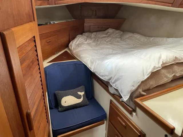 Slide: The Image of Cozy cabin interior of 1987 Pacific Seacraft PS37 with bed and blue chair. - 17