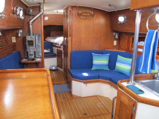 Slide: The Image of Interior of 1987 Pacific Seacraft PS37 sailboat with wooden furnishings and blue cushions. - 2