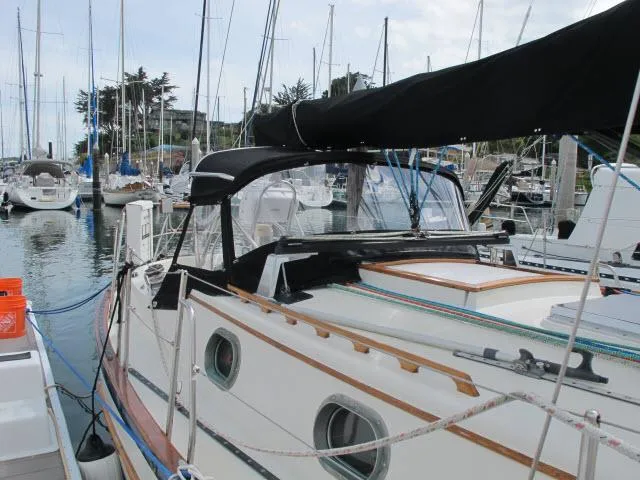 Slide: The Image of 1987 Pacific Seacraft PS37 sailboat docked in marina, featuring classic design and black canopy. - 30