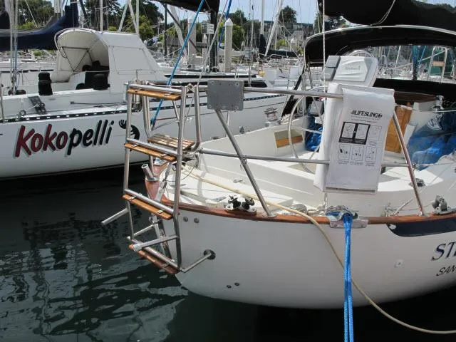 Slide: The Image of 1987 Pacific Seacraft PS37 sailboat docked in marina, featuring a stainless steel ladder. - 34