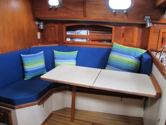 Slide: The Image of Cozy 1987 Pacific Seacraft PS37 sailboat interior with blue seating and striped cushions. - 4