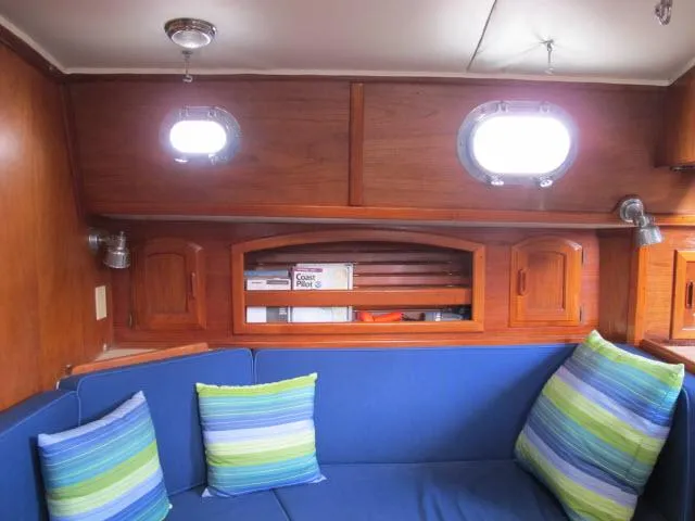 Slide: The Image of Interior of 1987 Pacific Seacraft PS37 sailboat with blue seating and striped pillows. - 5