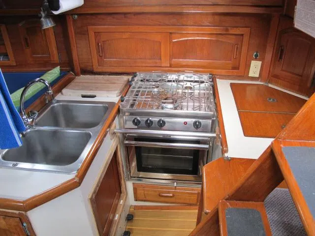 Slide: The Image of 1987 Pacific Seacraft PS37 yacht kitchen with stove, sink, and wooden cabinetry. - 6