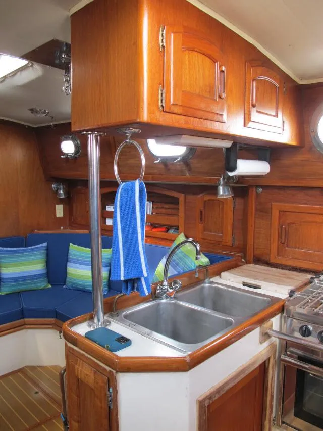Slide: The Image of 1987 Pacific Seacraft PS37 yacht interior with wooden cabinetry and cozy seating area. - 7