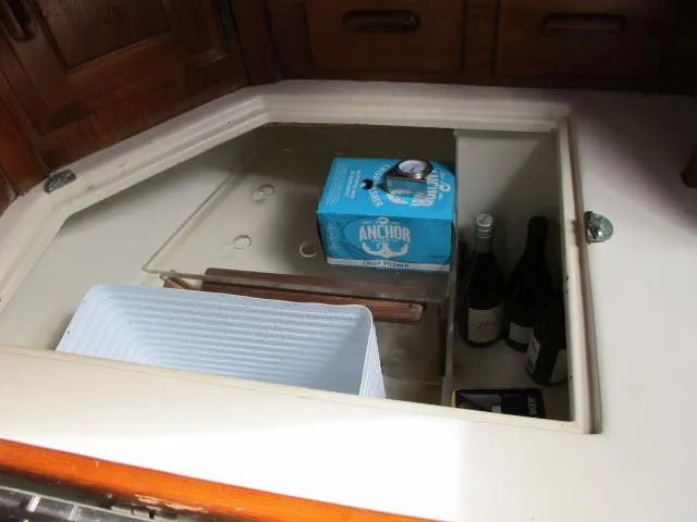 Slide: The Image of Storage compartment in 1987 Pacific Seacraft PS37 yacht with beverages and containers. - 8