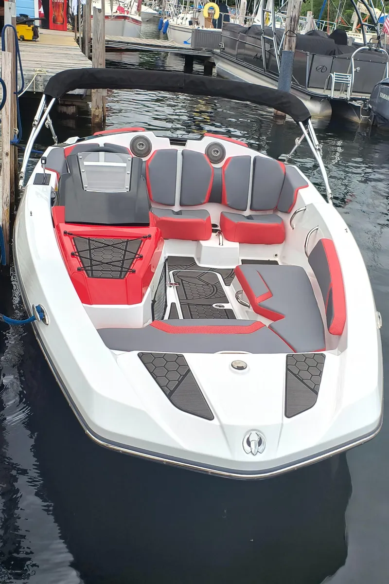 Slide: The Image of 2025 Scarab 165 LX boat docked, featuring sleek design and red-gray seating. - 7