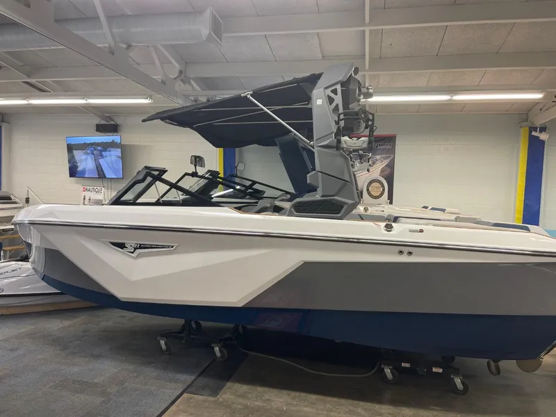 Slide: The Image of 2025 Nautique Super Air Nautique S21 boat in showroom, side view. - 22