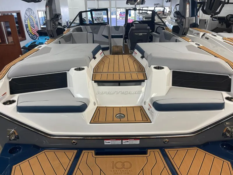 Slide: The Image of 2025 Nautique Super Air Nautique S21 boat interior with teak flooring and seating. - 23